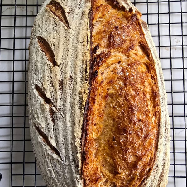 Freshly baked sourdough loaf sliced on a board